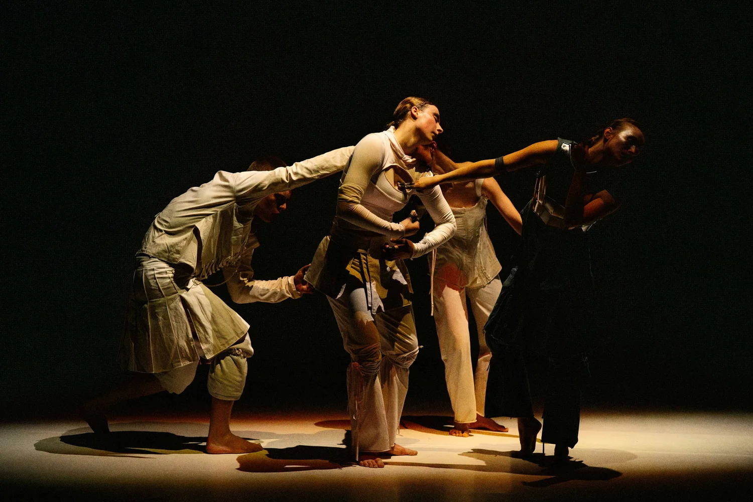 Performers linked together on stage