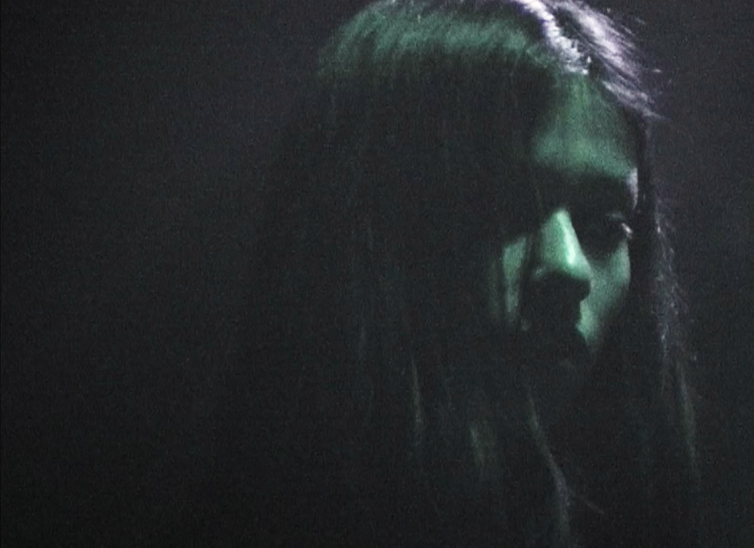 A dark figure in green light